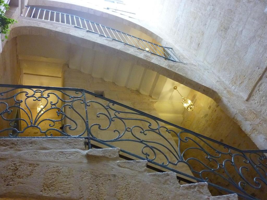 eine Treppe mit einem schmiedeeisernen Geländer in einem Gebäude in der Unterkunft L'Invitation au Voyage in Bordeaux