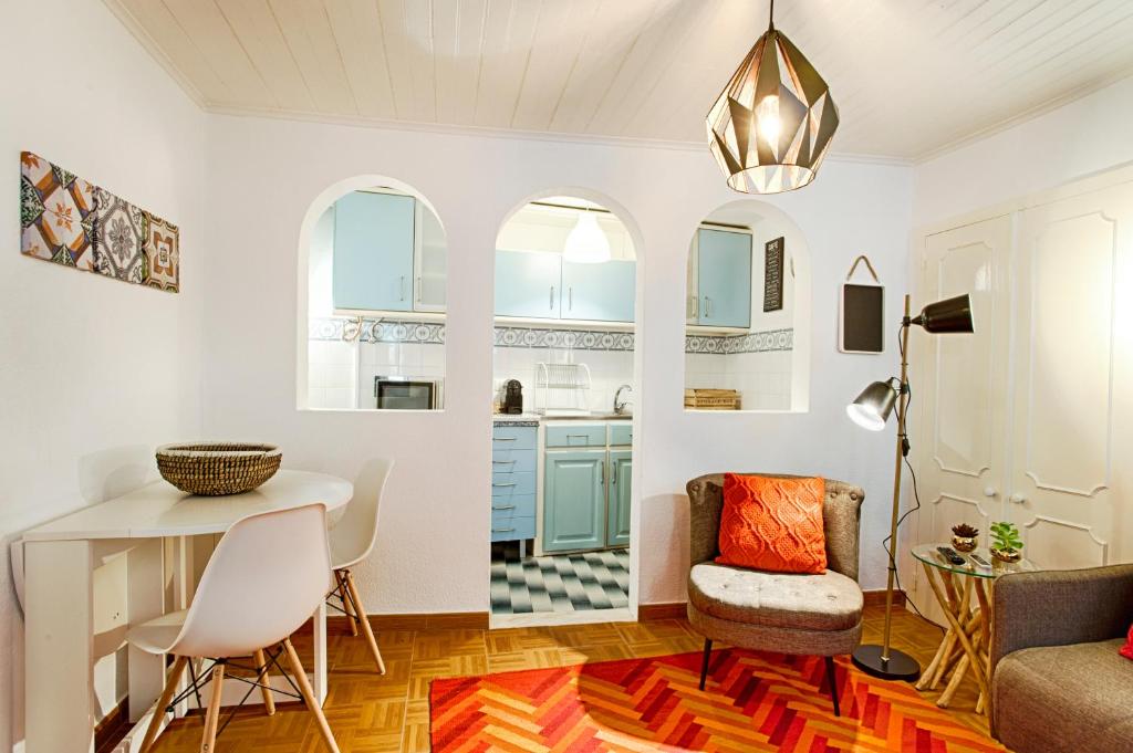 リスボンにあるBmyGuest - Mouraria Central Apartment IIのキッチン(青いキャビネット、テーブル、椅子付)