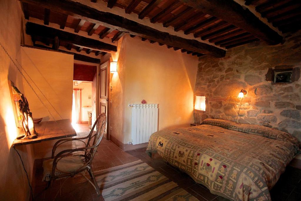 Un dormitorio con una cama y un escritorio en una habitación. en Podere di Maggio - Casa Grande, en Santa Fiora