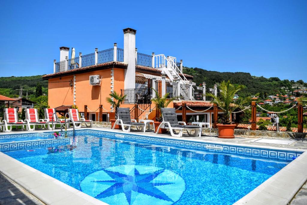 una piscina con una casa sullo sfondo di Boutique Villa Rosa Dei Venti a Balchik