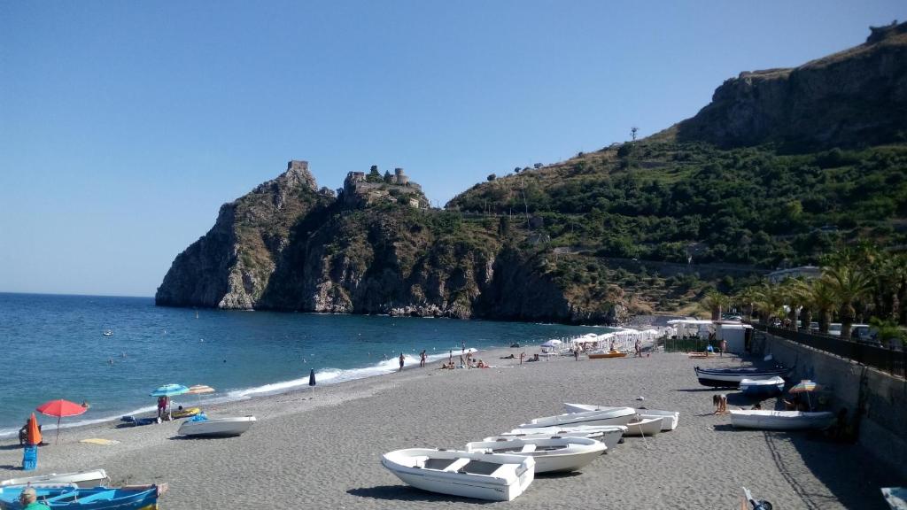 una playa con un montón de barcos en la arena en B&B Villa Carmen en SantʼAlessio Siculo