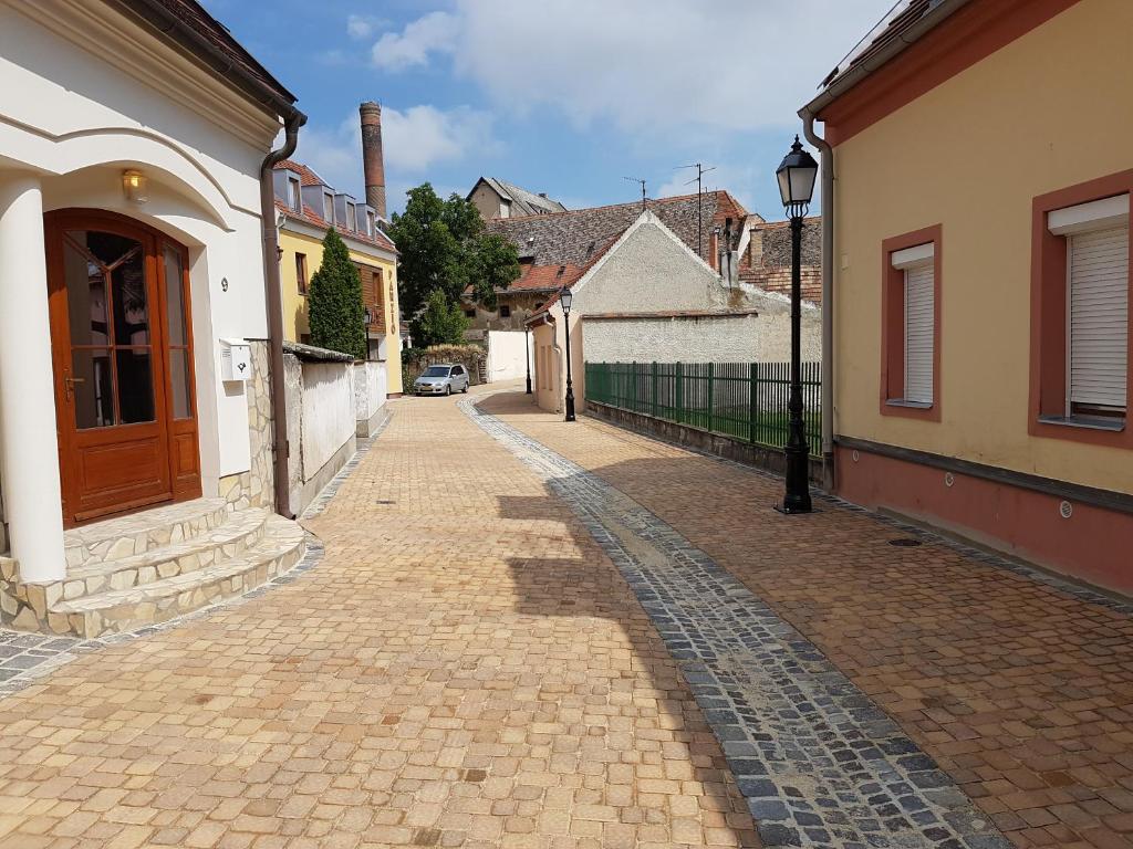 a cobblestone street in a town with buildings at Apartman Kaszás Central in Mosonmagyaróvár