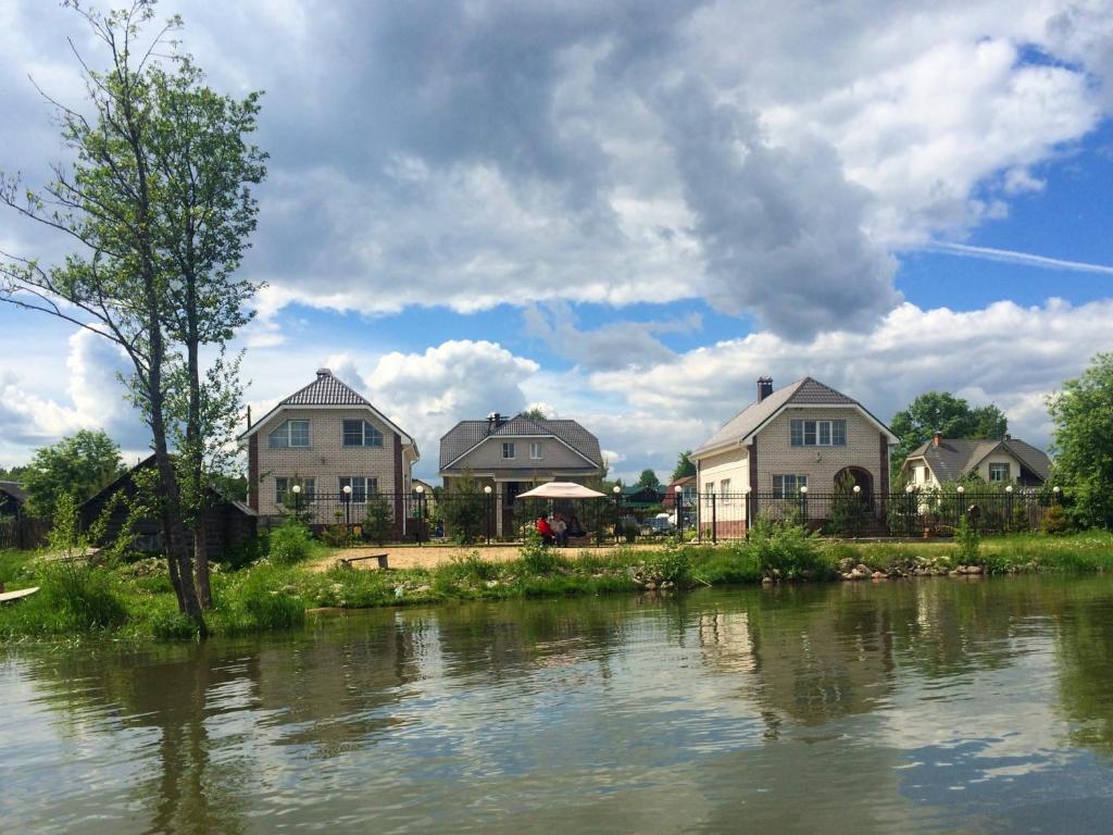 a group of houses next to a river at Guest house Ura Seliger in Sloboda