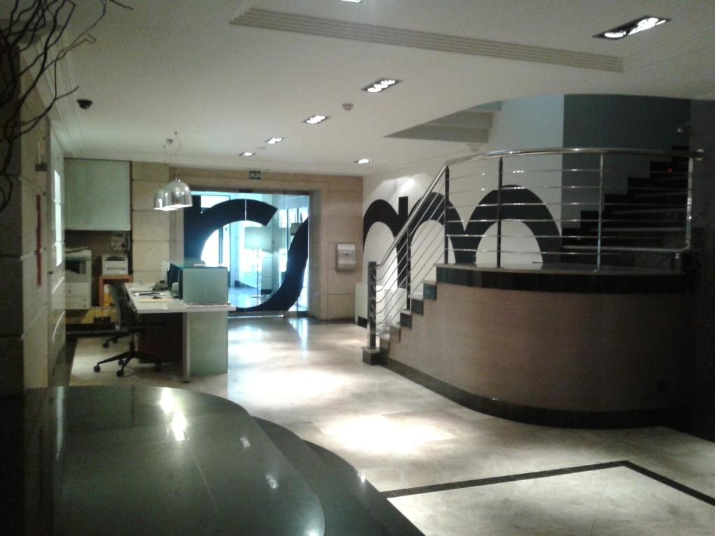 an office lobby with a staircase and a desk at Hotel Room in Pontevedra