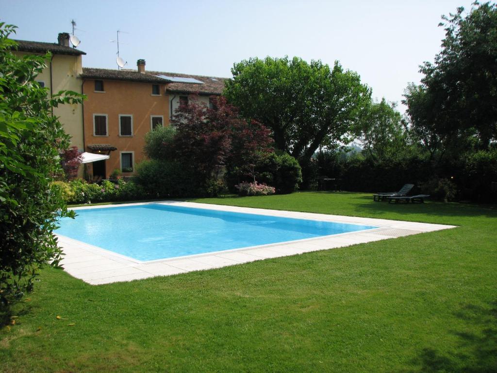 a swimming pool in the yard of a house at B&B Casale Onida in Volta Mantovana