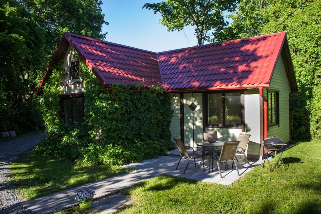 een huis met een rood dak en een tafel en stoelen bij Nurmeveski Holiday House in Nurme