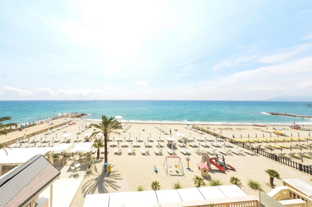 a view of the beach from the balcony of a resort at Blu Sea apartments in Pietra Ligure