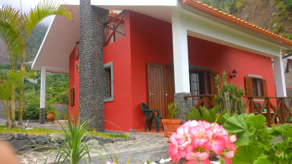 a red and white house with a tree and flowers at Casa del Mar in Santana