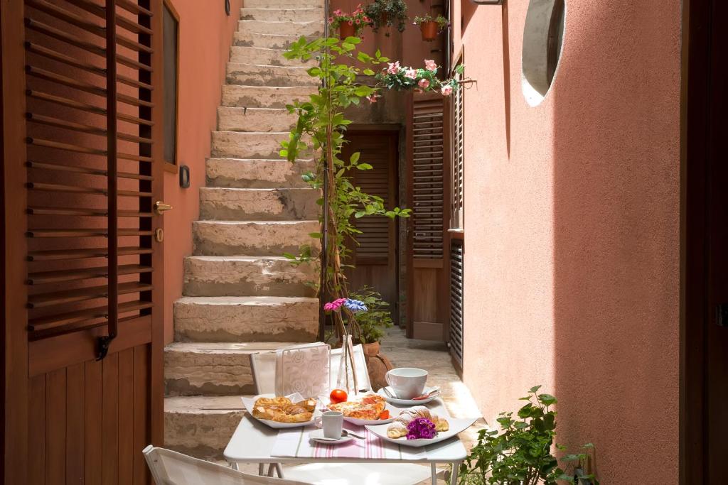 a table with two plates of food on a street at Il Cortile Fiorito in Trapani