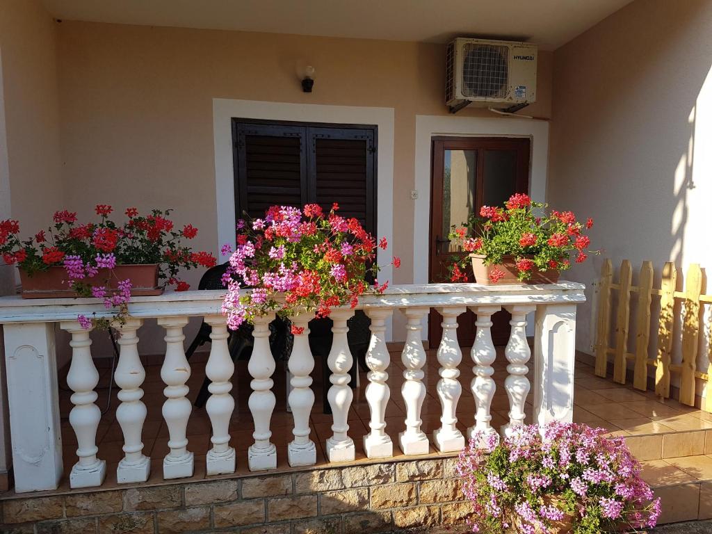 a white railing with flowers on a balcony at Apartman Vito in Medulin