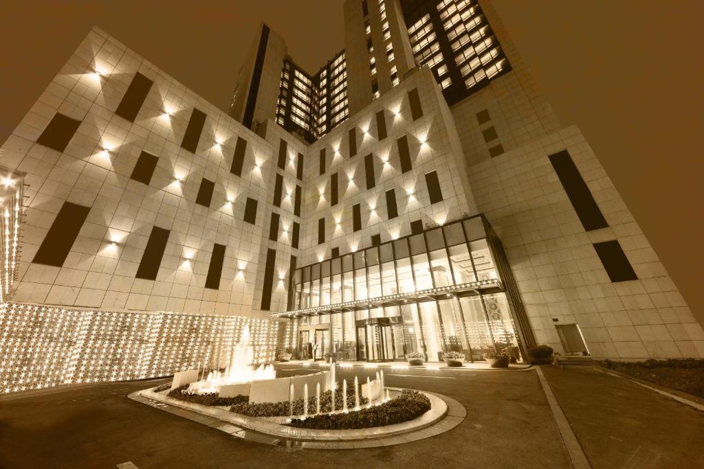 a large building with a fountain in front of it at Paramount Gallery Hotel in Shanghai