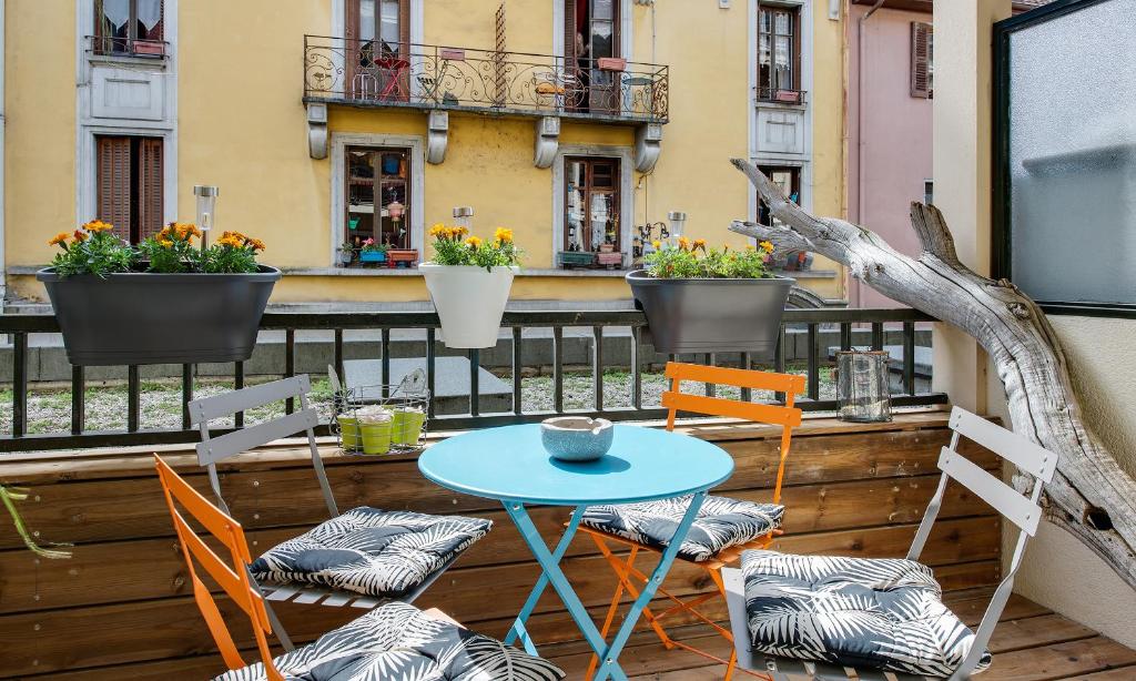 a patio with a table and chairs on a balcony at Appartement Le Venise in Annecy