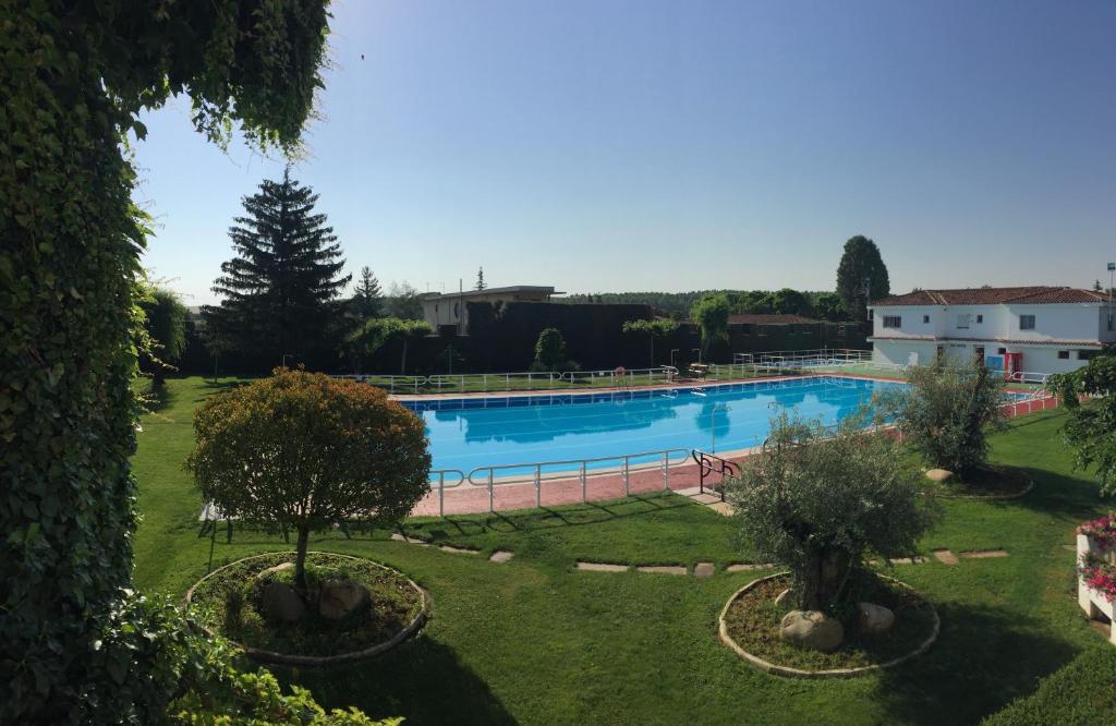 a large swimming pool in a yard with trees at Hotel Valjunco in Valencia de Don Juan