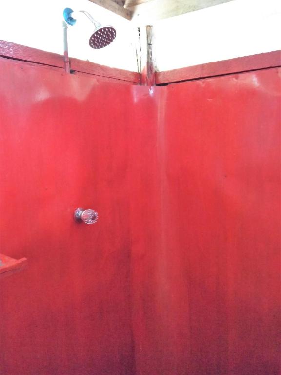 una parete rossa con una porta rossa con scarico di Lodge Jungle Wolf Expeditions a Yucuruche
