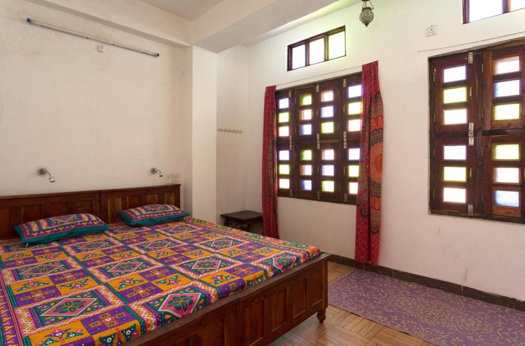 una camera da letto con un letto in una stanza con finestre di Hotel Pawan's Palace a Pushkar