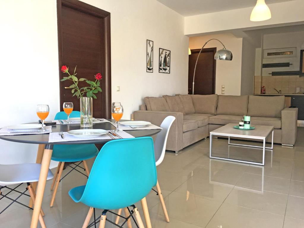 Agios OnoufriosにあるLight Blue Apartmentのリビングルーム(テーブル、椅子、ソファ付)