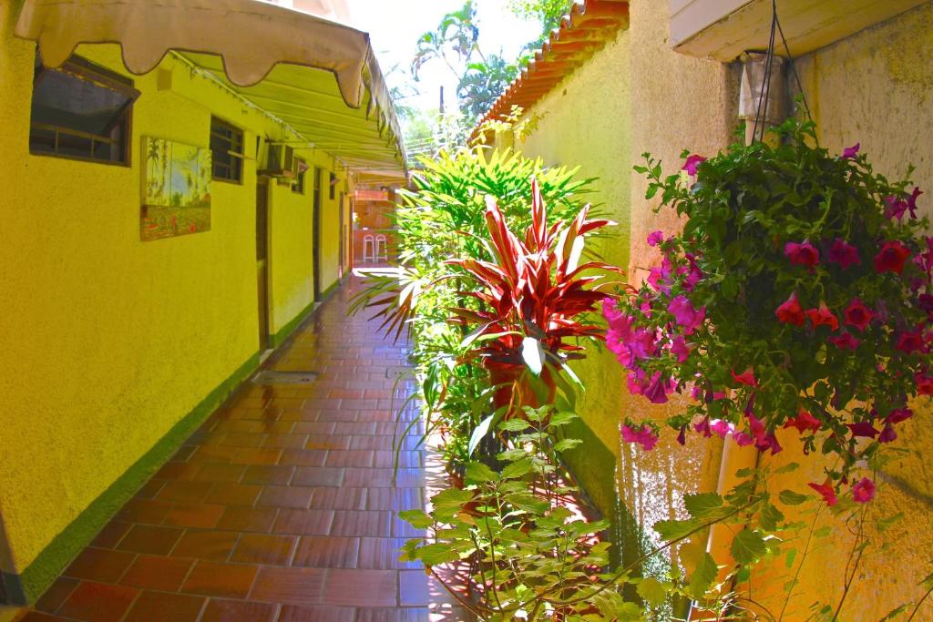 an alley with plants and flowers in a building at Pousada e Hostel Barra da Tijuca in Rio de Janeiro