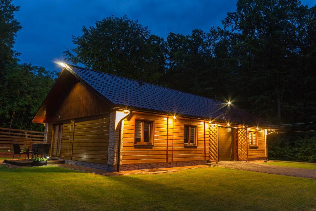 een hut die 's nachts verlicht is met lichten aan bij Zagroda Nad Kotelnią in Pawłowa