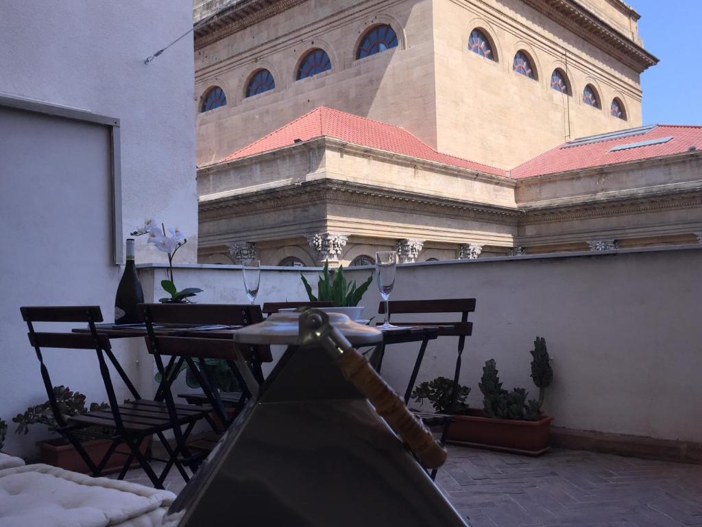 un patio con mesa y sillas y un edificio en La Terrazza sul Massimo, en Palermo