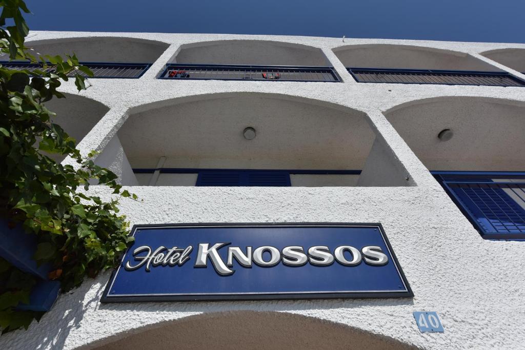ein Schild an der Seite eines Gebäudes in der Unterkunft Knossos Hotel in Tolo