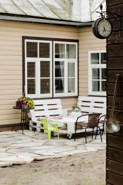 a patio with a table and chairs and a clock at Posti 19 Apartment in Haapsalu