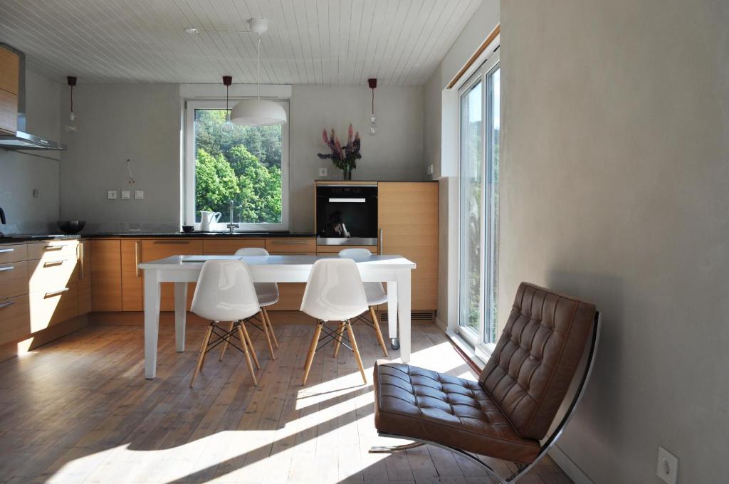 a kitchen with a white table and white chairs at Hei og Hav - i Torbjørn Egners Ferierike in Mandal