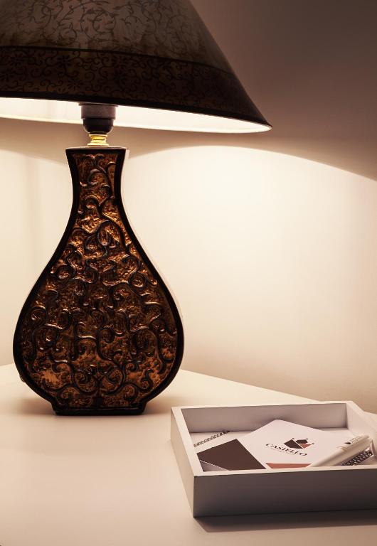 a lamp sitting on a table next to a box at Castello Boutique Hotel in Čačak