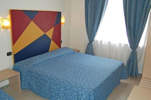 a bedroom with a bed with a blue comforter at Mare Blu in Gioiosa Marea