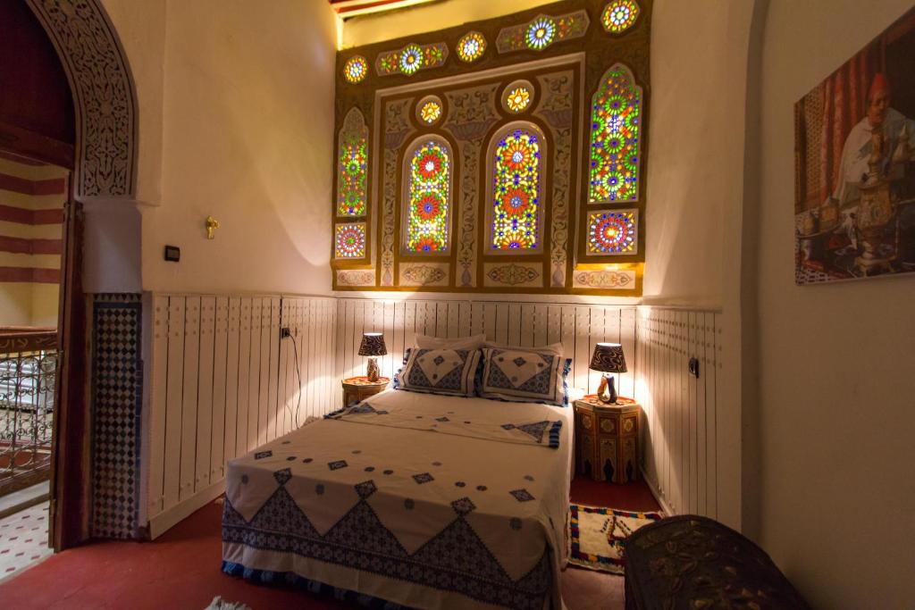 um quarto com uma cama com um vitral em Riad Diwan em Fez