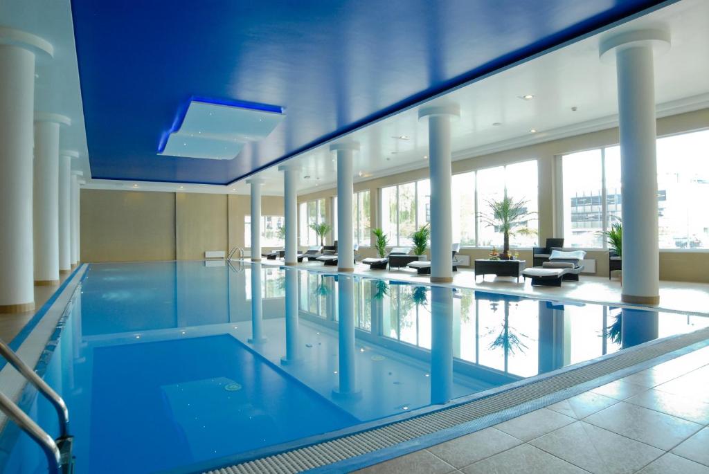 a large swimming pool in a large building at Ambasador Premium in Łódź