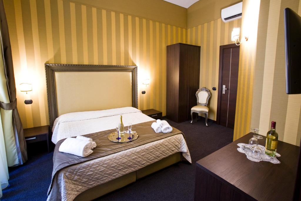 a hotel room with two beds and a table with towels at Nice Rome Holiday in Rome