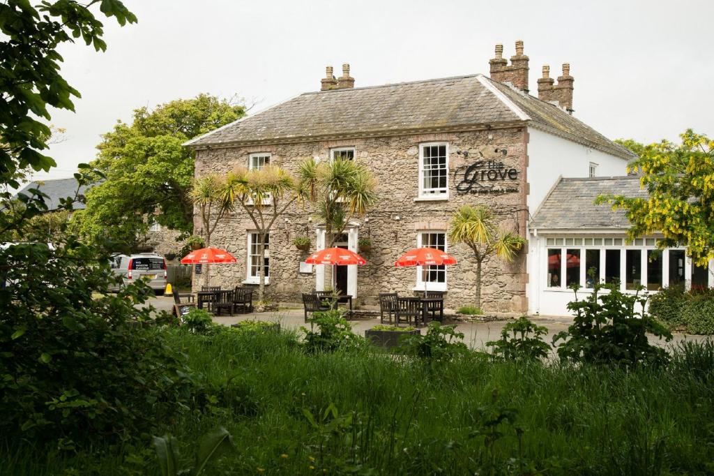 a building with red umbrellas in front of it at The Grove in St. Davids