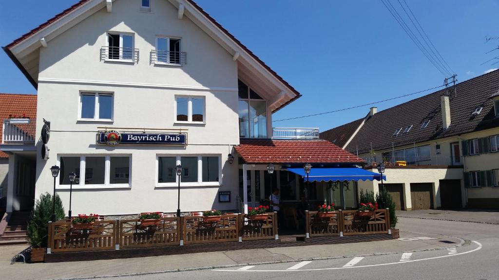 a white building with a restaurant in front of it at Apartments zum Bayrisch Pub in Weißenhorn
