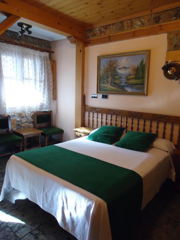 a bedroom with a large green and white bed at Picon del Conde in Monasterio de Rodilla
