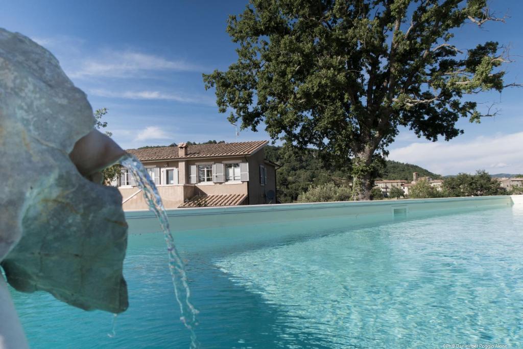 una persona bebe agua de una piscina en Bio Agriturismo Poggio Aione, en Saturnia