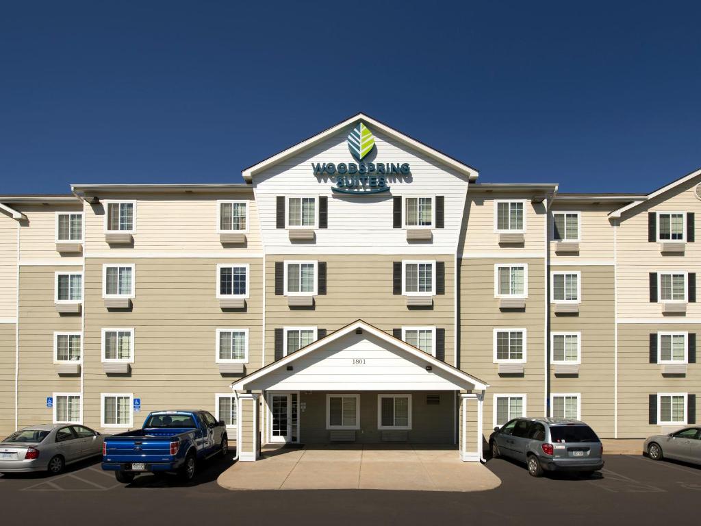 un gran hotel con coches estacionados frente a él en WoodSpring Suites Topeka, en Topeka