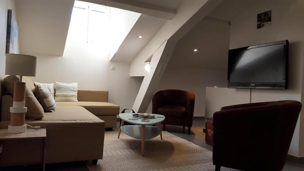 Una sala de estar con un sofá y un televisor de pantalla plana. en Cannes,croisette,palais des festivals,plages, en Cannes