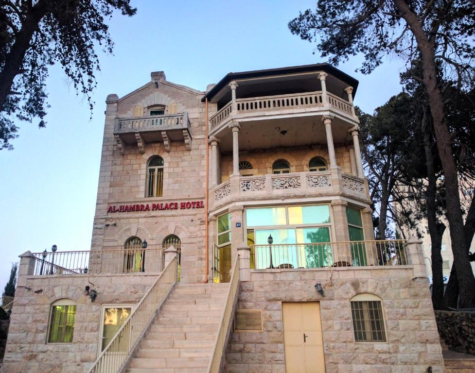 an old house with a staircase in front of it at Alhambra Palace Hotel Suites - Ramallah in Ramallah