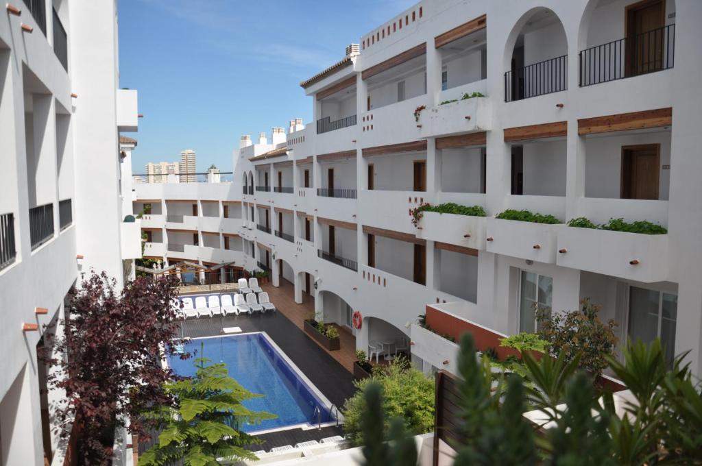 an apartment building with a swimming pool in the middle at Hotel Puerto Mar in Peñíscola