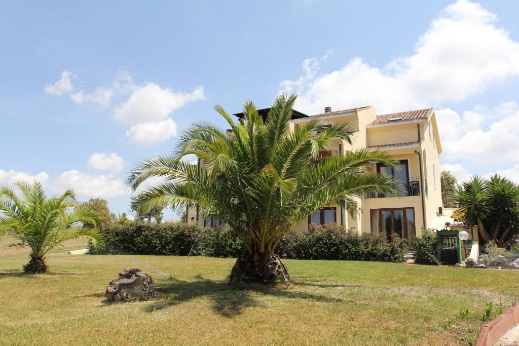 uma palmeira em frente a uma casa em Palmas Dorada em Olmedo