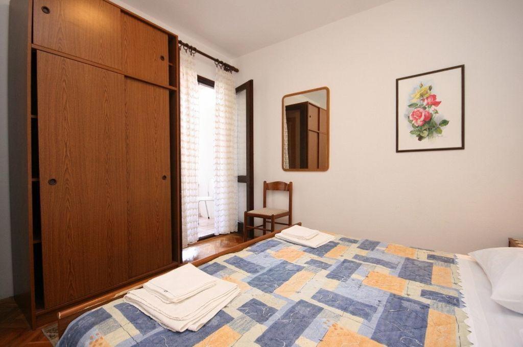 a bedroom with a bed and a dresser at Apartments Renco in Novalja
