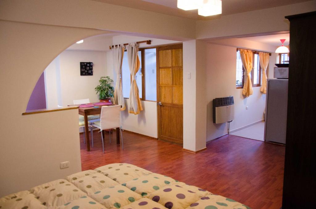 a bedroom with a bed and a table and a kitchen at Historical Center Apartments in Cusco