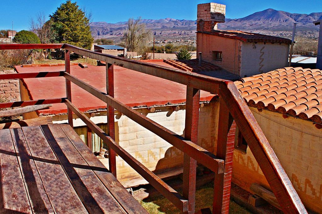 eine Holztreppe, die zu einem Gebäude mit einem Dach führt in der Unterkunft El Sol Hostel de Humahuaca in Humahuaca