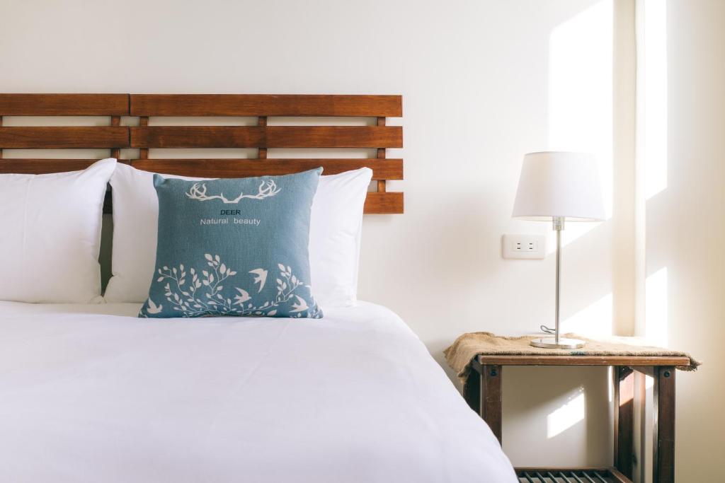 une chambre avec un lit avec un oreiller bleu dans l'établissement Zeroplus旅宿 渡假包棟villa, à Hengchun Old Town