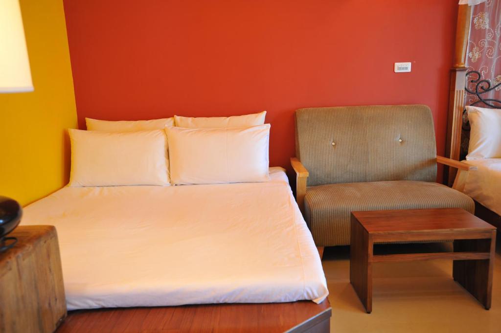 a small bedroom with a bed and a chair at 花蓮觀月民宿-寵物友善-含車位 in Hualien City