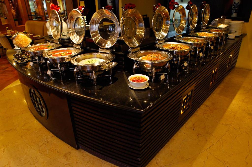 a buffet line with bowls of food on it at Surabaya Suites Hotel Powered by Archipelago in Surabaya
