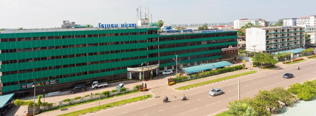 um grande edifício verde com uma rua em frente em Mekong Hotel em Vientiane