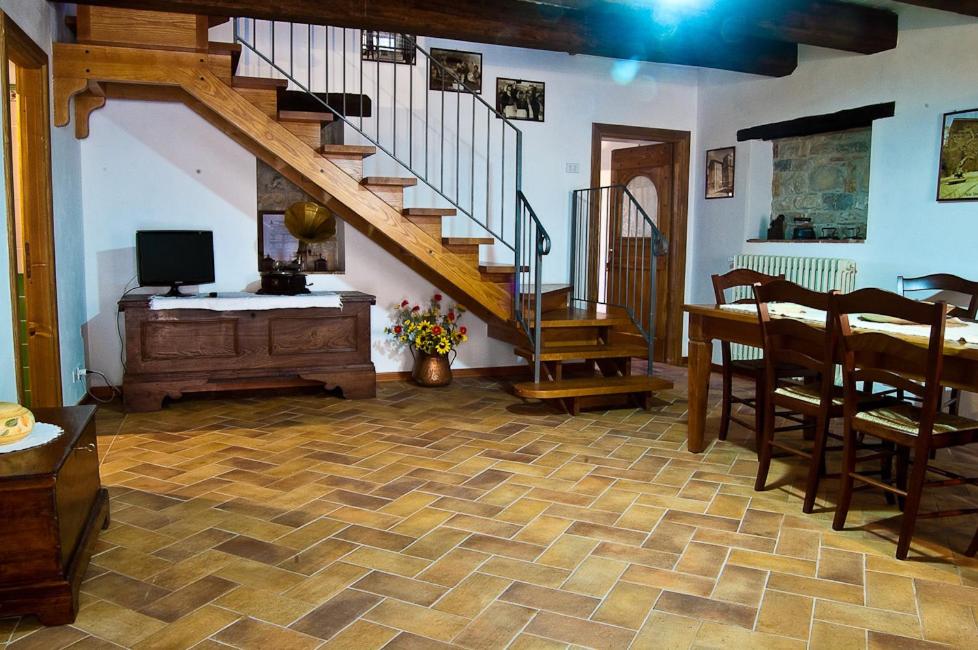 uma sala de estar com uma escada, uma mesa e uma televisão em Bed And Breakfast Pa' Carrera em Fragneto Monforte