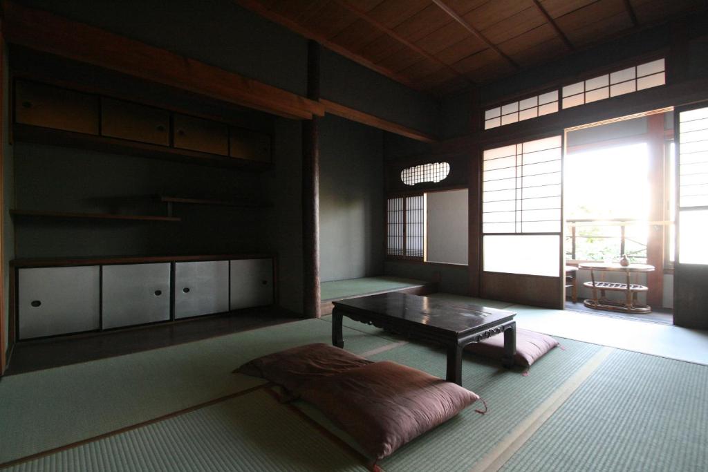 un soggiorno con un tavolo e una grande finestra di HARUYA Naramachi a Nara