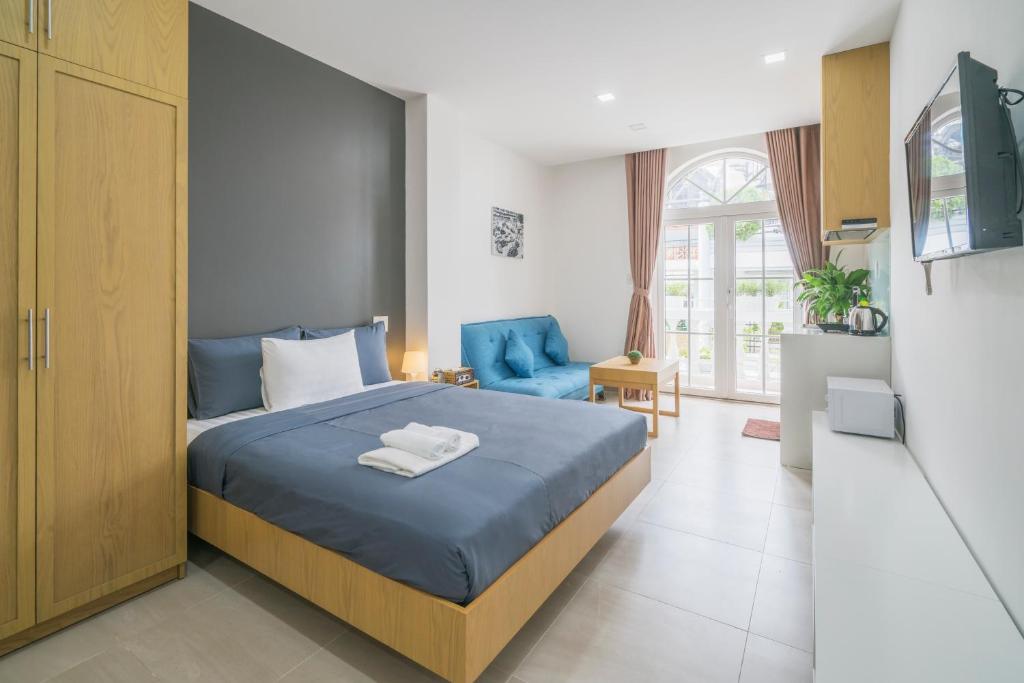 a bedroom with a blue bed and a blue chair at Babylon D3 Serviced Apartment in Ho Chi Minh City